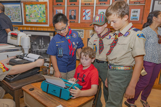 Scout members typing on an old typewriter