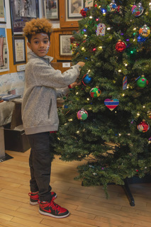 Young boy decorating tree
